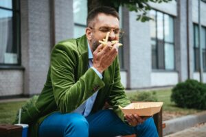 man-sitting-on-bench-eating-french-fries-and-other-foods-to-avoid-with-DDD