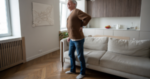 Adult experiencing spinal stenosis symptoms including back and leg pain while walking.