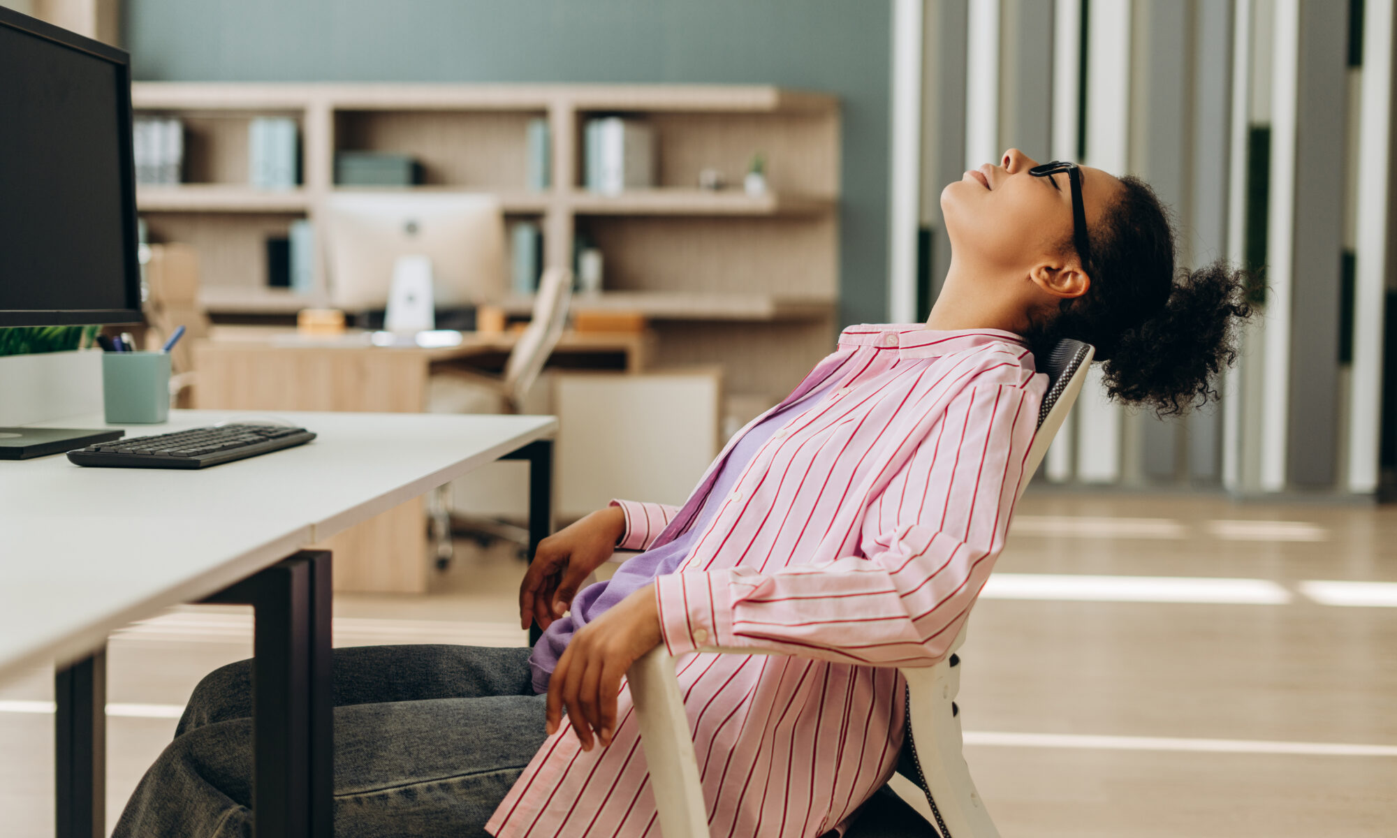 office work falling back in chair due to back pain from sitting too long