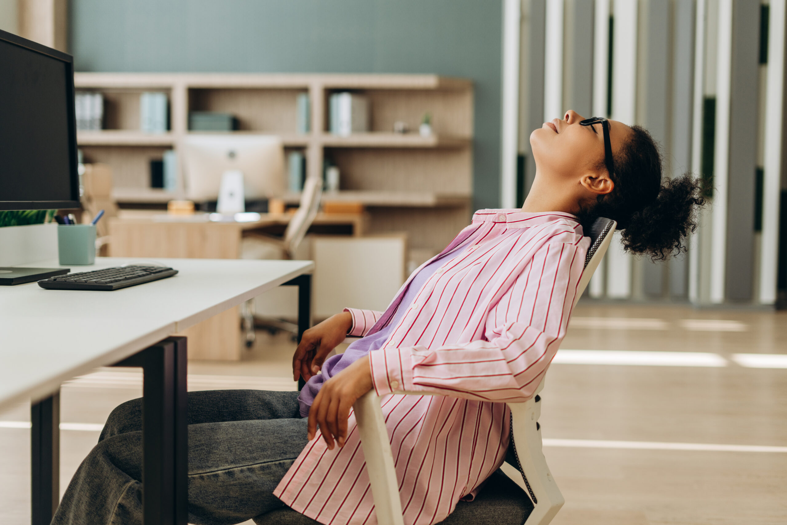 office work falling back in chair due to back pain from sitting too long