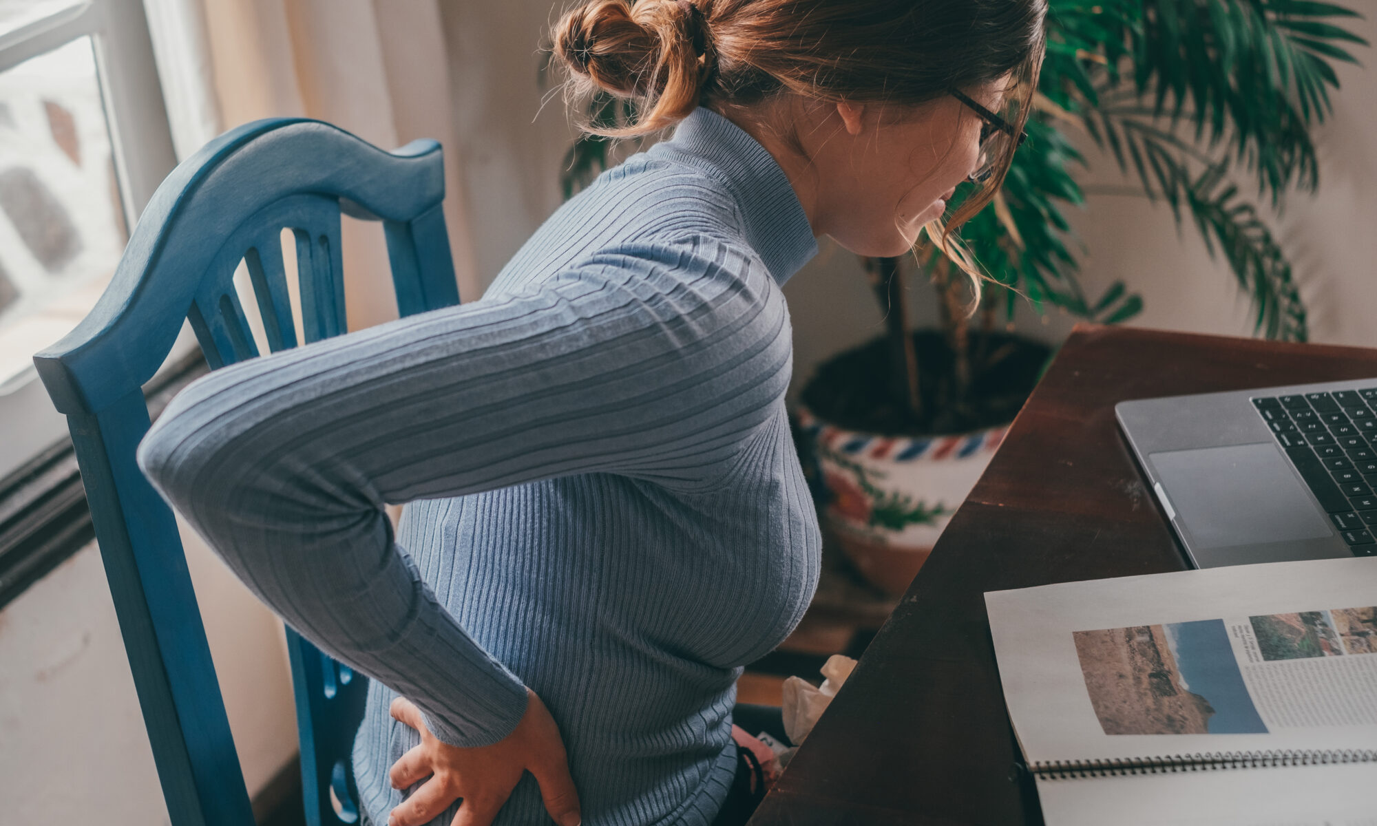 Woman with random spine pain while sitting at desk